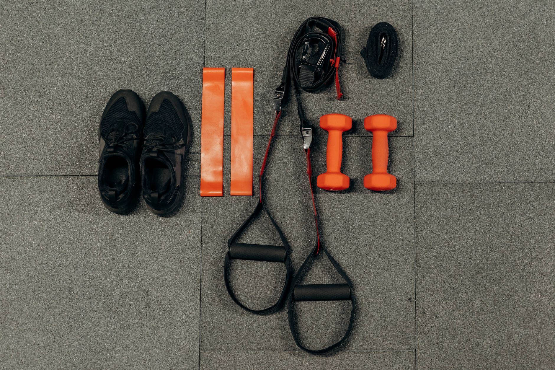 Trainingsausrüstung für den 4-Wochen-Plan: Widerstandsbänder, Kurzhanteln und Sportschuhe